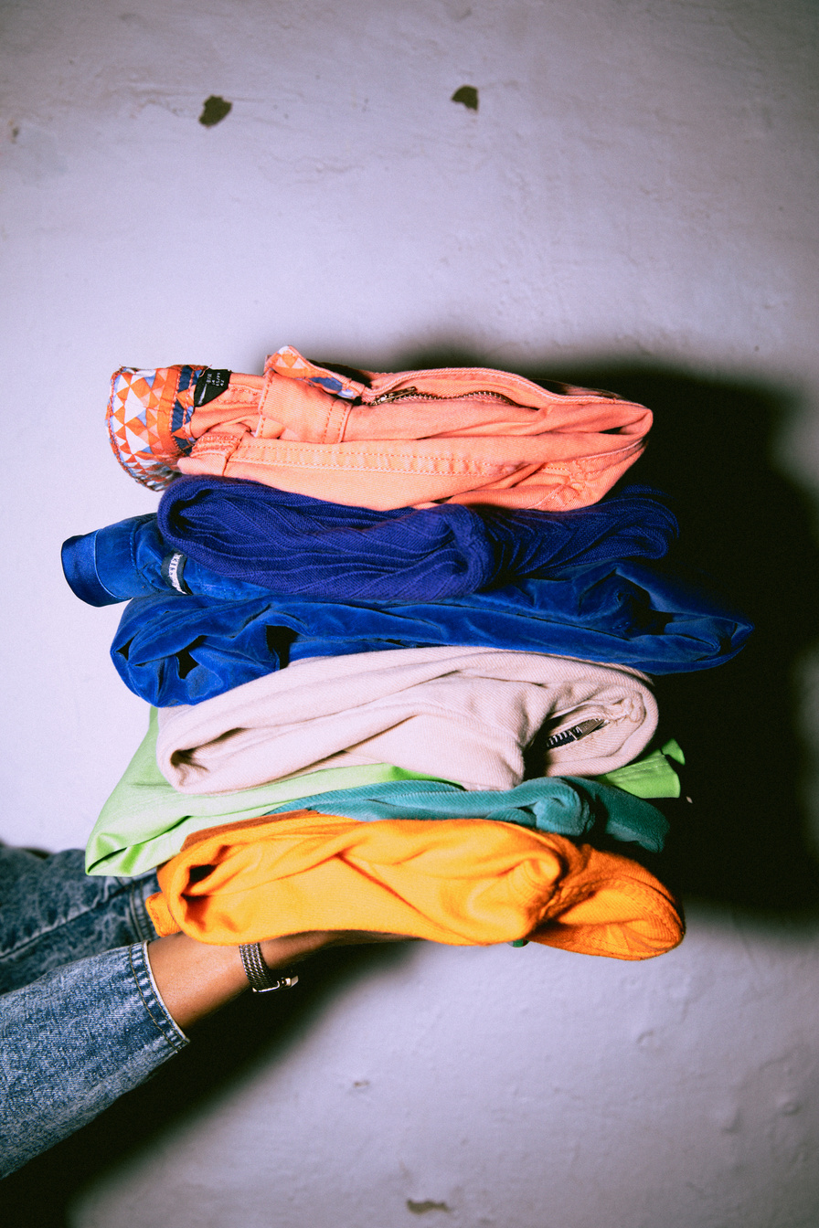 Person Holding a Stack of Folded Clothes